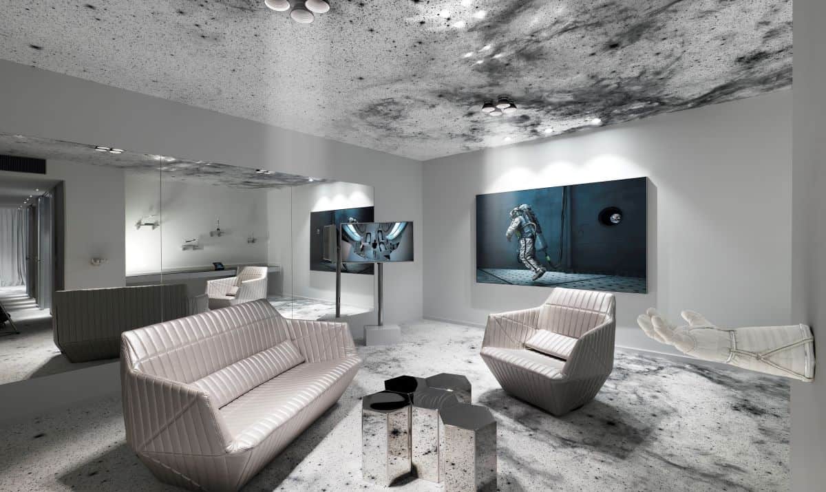 Space themed suite with floating bed, pictures of astronauts, galaxy themed ceiling and flooring