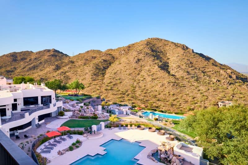 Exterior overhead view of ADERO Scottsdale and pools perched on desert mountain during daytime