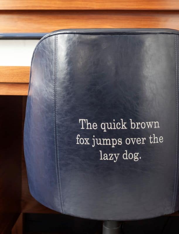 Back of leather chair with typewritten words "The quick brown fox jumps over the lazy dog"