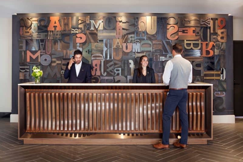 Reception desk with two staff and a guest being helped