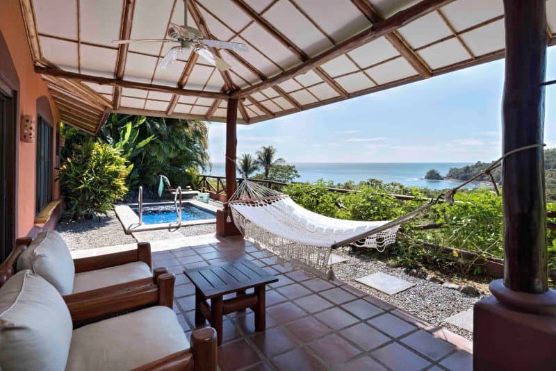 Junior suite patio with thatched roof, hammock and plunge pool overlooking ocean