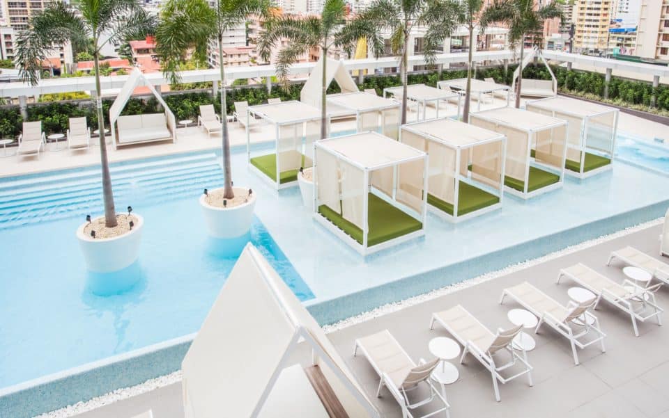 Rooftop pool with overwater cabanas and loungers on the deck